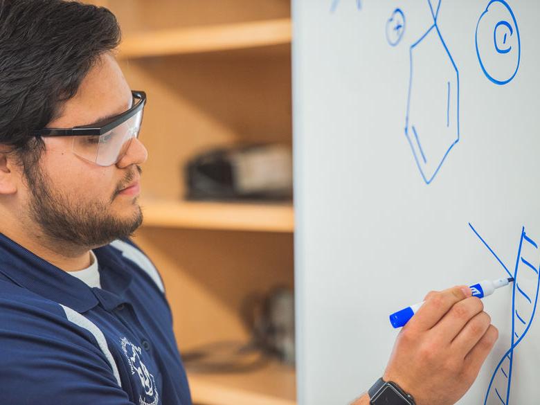 Student drawing on a white board.